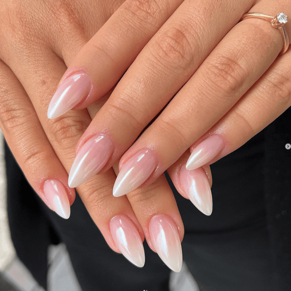 Ombré French nails on long almond nails, fading from pink to white